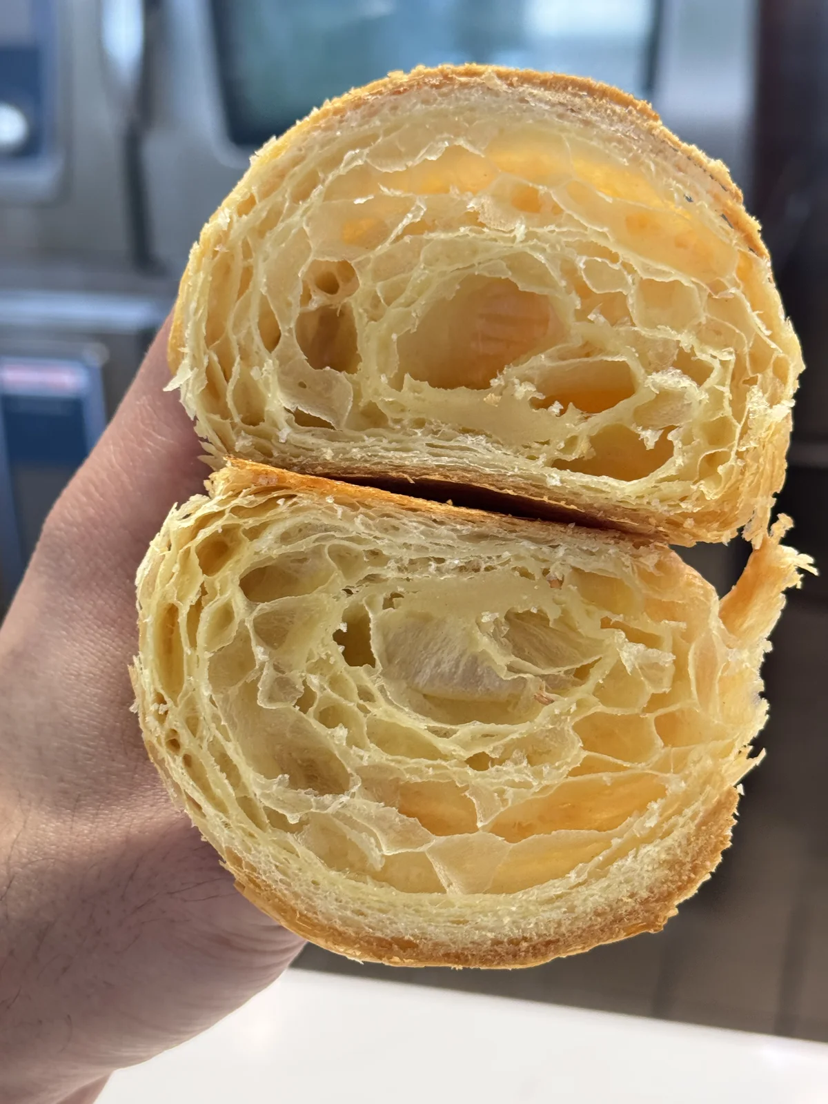 Cross-section of a hand-laminated croissant showing airy honeycomb layers, baked at The Cake Pantry in Fishers, Indiana