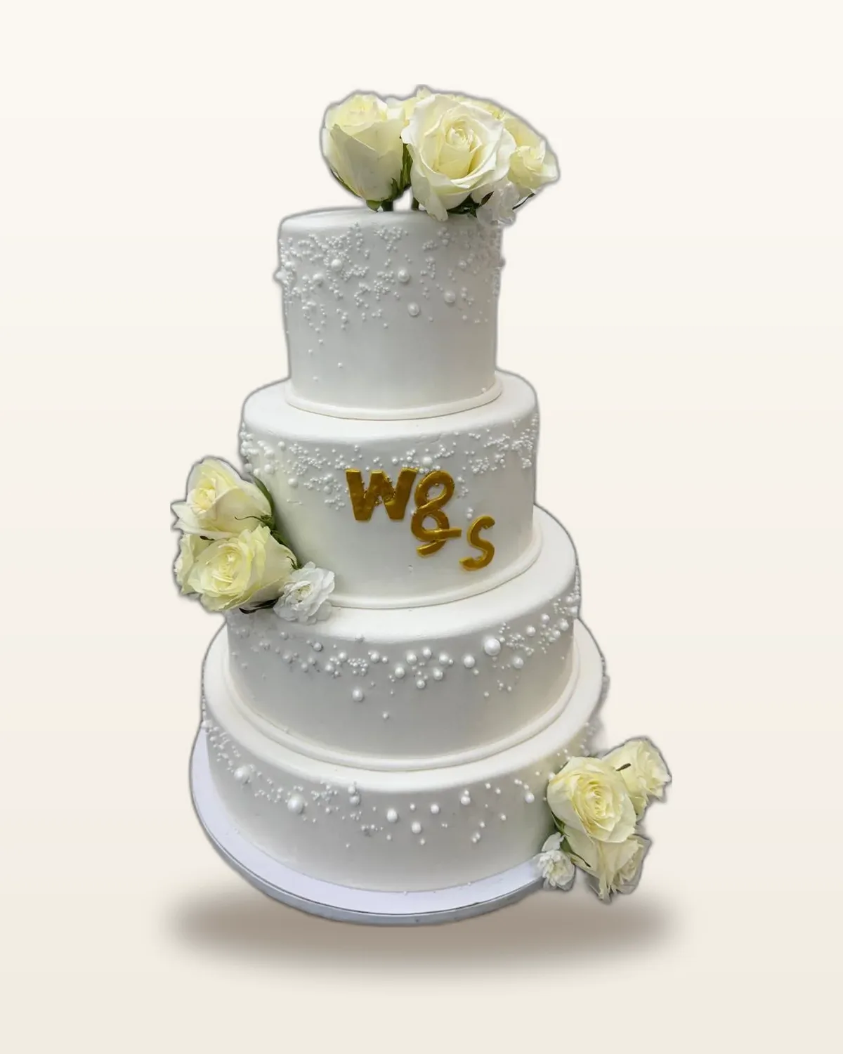 Layered celebration cake topped with fresh berries and edible flowers